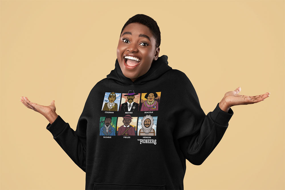 A person smiles with arms raised, wearing 'The Pioneers' AR Enhanced Hooded Unisex Sweatshirt featuring illustrated portraits of Black historical figures, against a plain beige background.