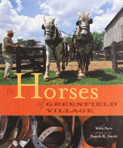 A man stands next to two large white Percheron horses harnessed to a wagon on a farm. The book cover, titled "The Horses of Greenfield Village," features horseshoes at the bottom.