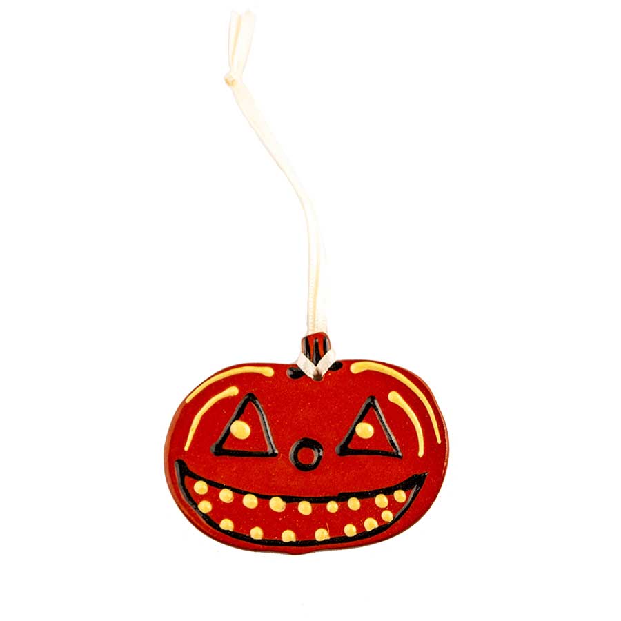 The Redware Pumpkin Ornament features a flat, orange jack-o-lantern with a wide, toothy smile, yellow accents, triangular eyes, and a white hanging ribbon—perfect for festive Halloween décor.