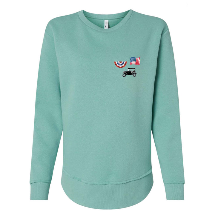 The Greenfield Village Model T Women's Sweatshirt in light teal features small embroidered designs—patriotic bunting, an American flag, and a vintage Model-T car—on the left chest. It has long sleeves and a rounded hem.