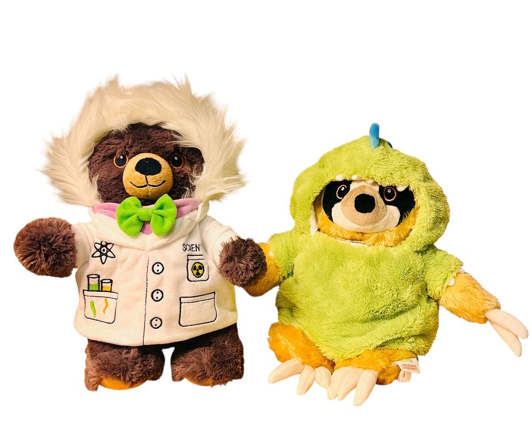 A brown bear wears the Plush Scientist Outfit—with a white lab coat and green bow tie—standing beside a sloth in a bright green dinosaur costume. Both plush toys inspire educational play and imaginative adventures.