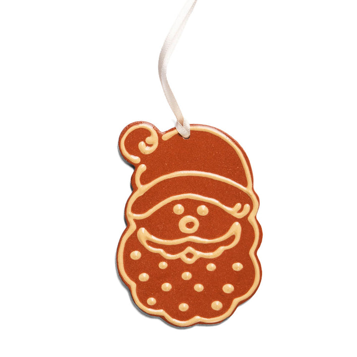 The Redware Santa Ornament is a handcrafted holiday decoration shaped like Santa’s face, finished with white icing details and a hanging ribbon—a festive piece inspired by Greenfield Village tradition.