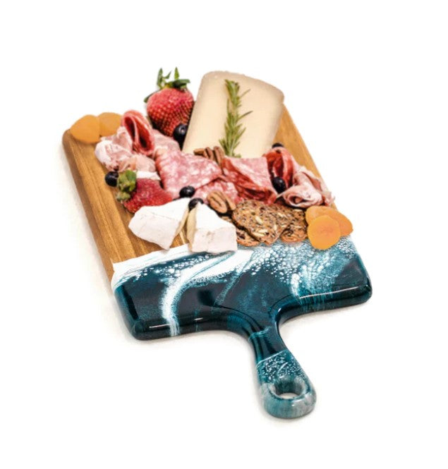 An Acacia Navy and Metallic Resin Cheeseboard topped with assorted meats, cheeses, crackers, strawberries, blueberries, apricots, and a sprig of rosemary, all arranged neatly on a white background.
