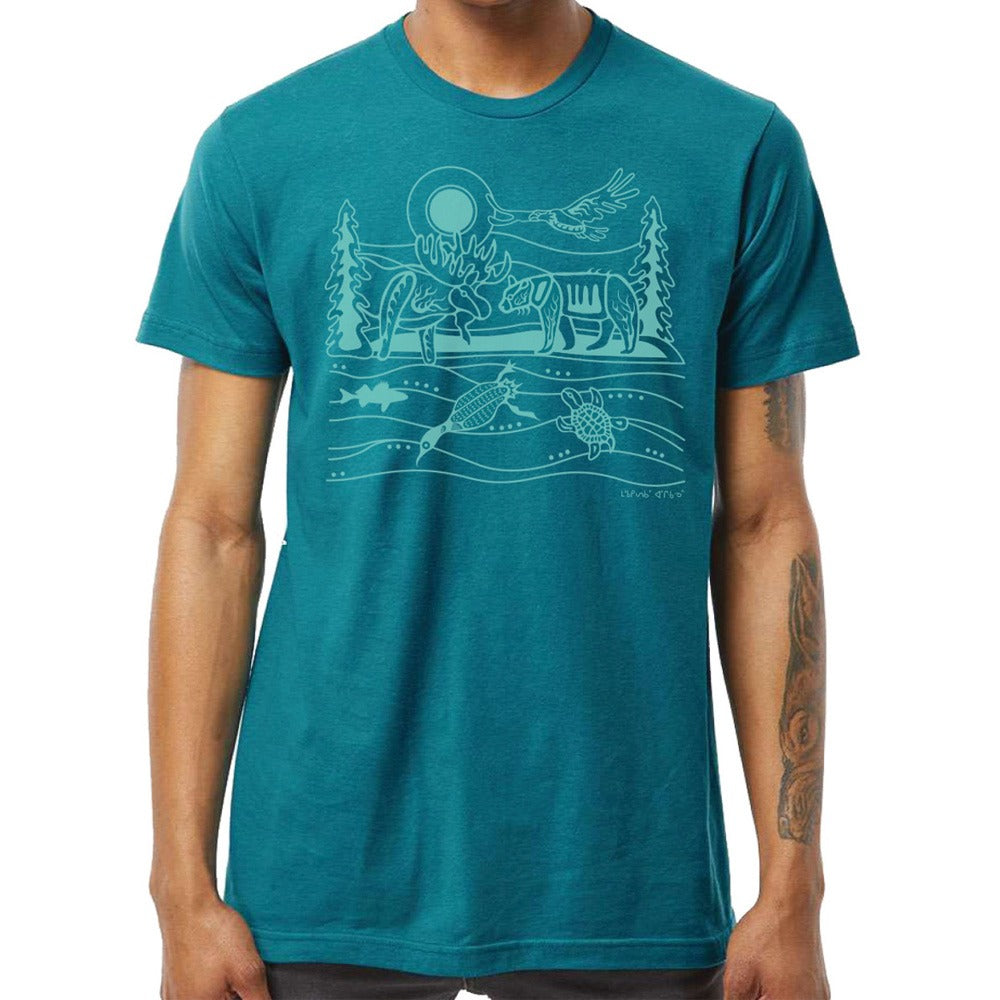 A person wearing the Native Northwest All My Relatives Moose T-Shirt with teal fabric and line art of a moose, trees, sun, fish, and turtles.