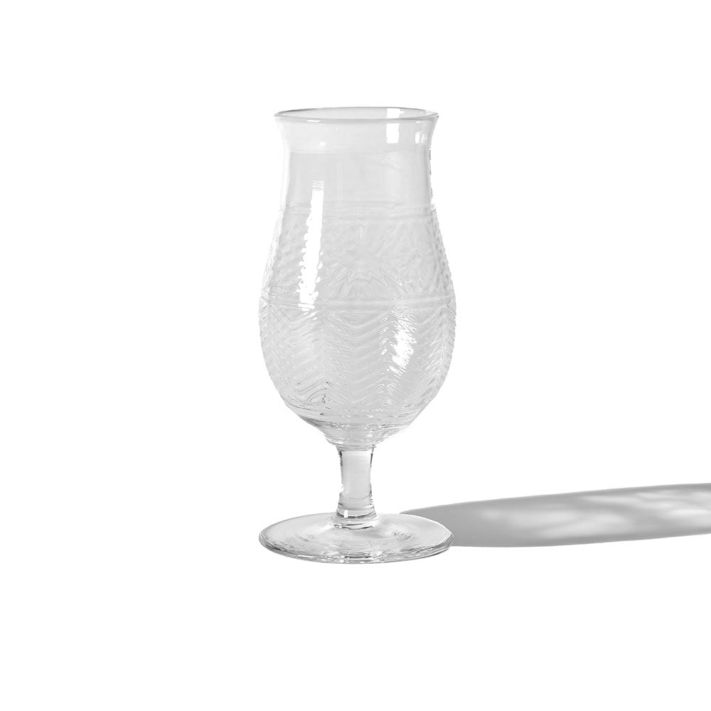 The American Heritage Molded Tulip Glass - Clear is an empty, textured goblet with a wide bowl and narrow stem, casting a right-side shadow on a white background.