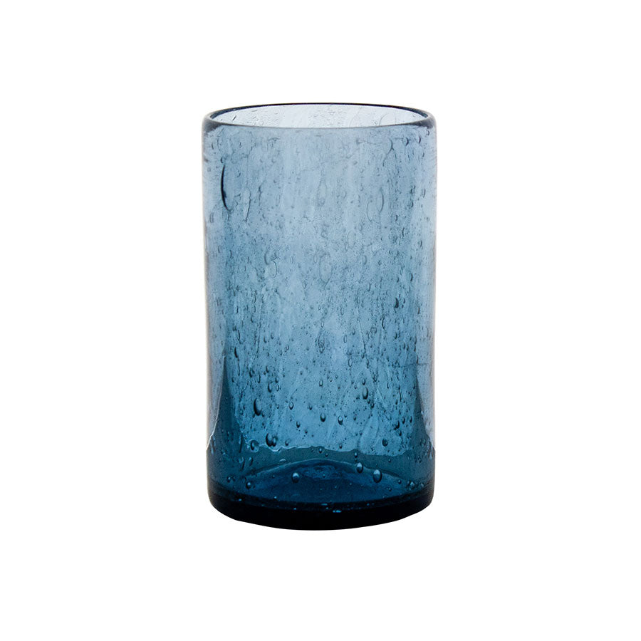 The Tumbler - Recycled is a blue, cylindrical glass with a thick base and bubble-like textures, shown empty against a white background.