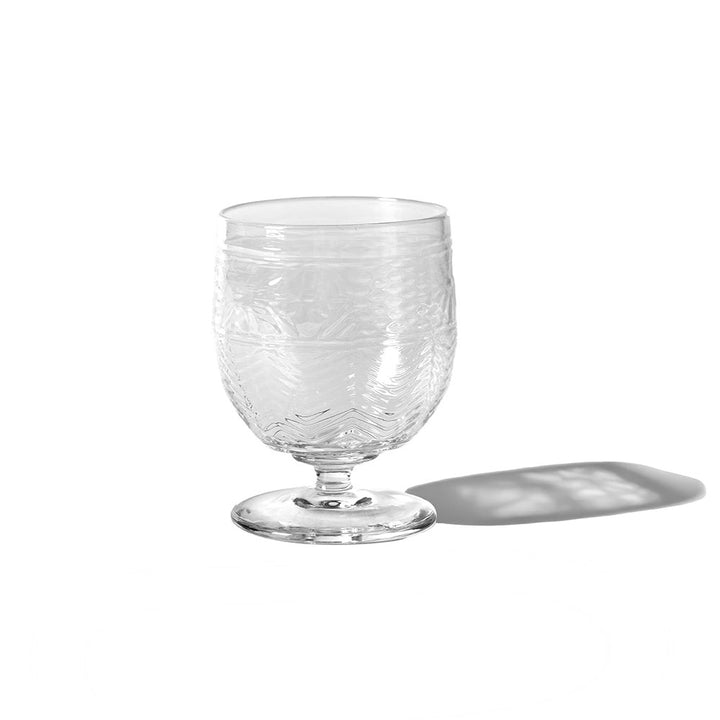 The American Heritage Molded Wine Goblet - Clear showcases a textured, patterned surface and rests on a white background, casting a soft shadow to the right.