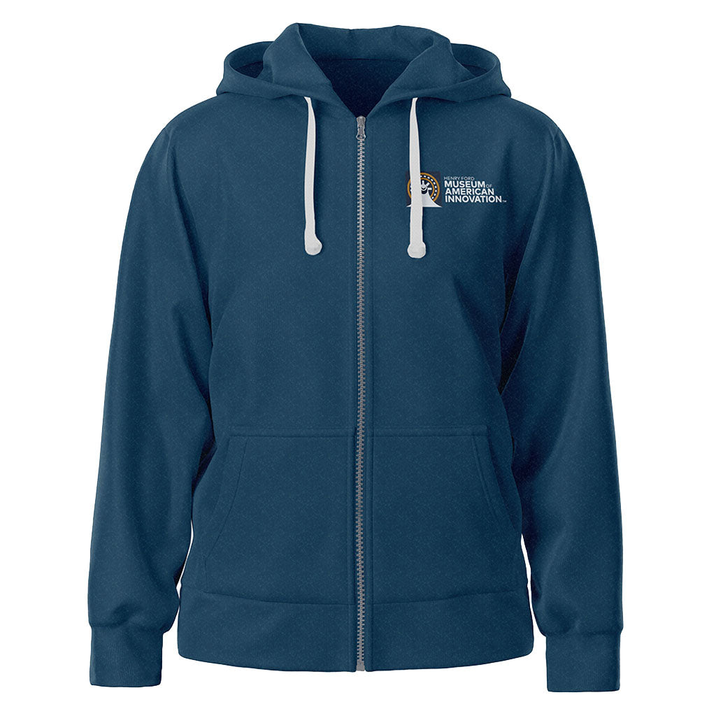 A navy blue zip-up hoodie with white drawstrings, front pockets, and a small white "Museum of American Innovation" logo on the left chest. Inspired by museum architecture, it’s The Henry Ford Museum Architecture Zip-Up Hooded Sweatshirt.